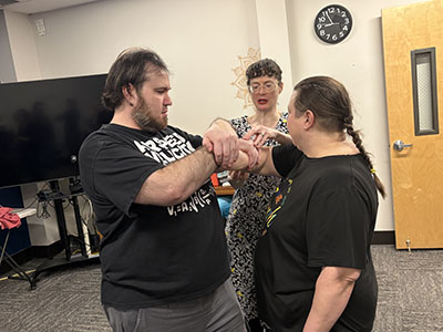 2 students practicing self defense techniques under watchful eye of the 1touch coach